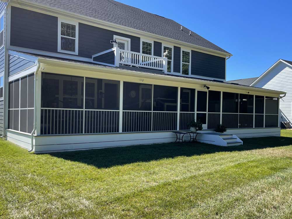 Large screened porch full length of blue home