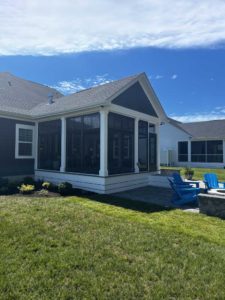 Bronze framed three season room on blue home with white trim