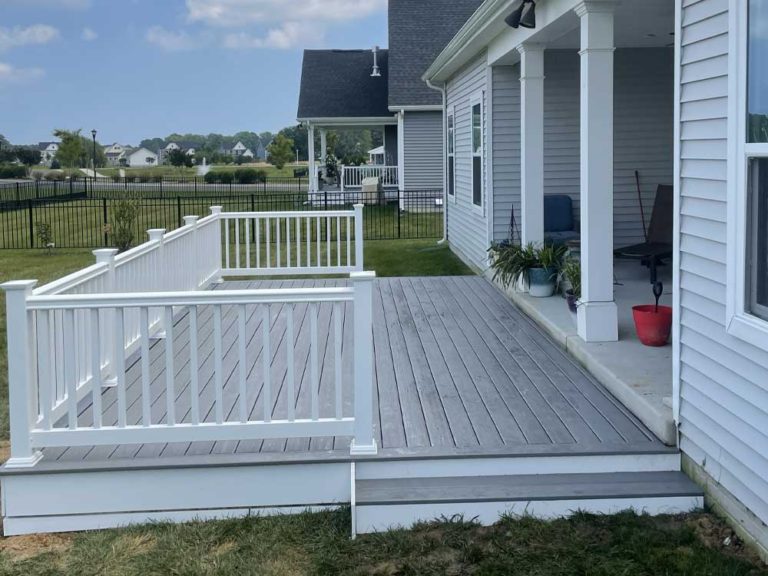 Gray ground level deck with white vinyl rail