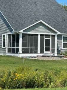 Screened porch with white trim and lattice on gray home